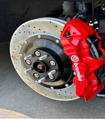 Red Brembo brake caliper on a drilled rotor